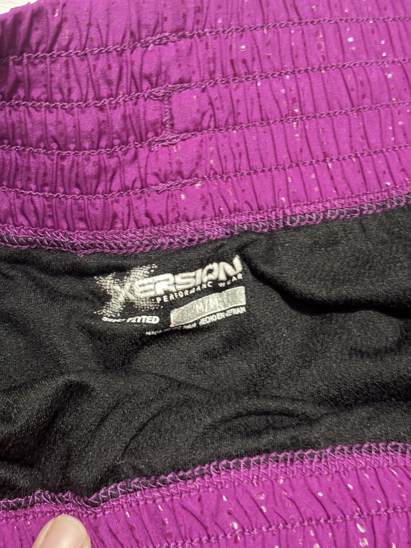 Xersion Performance Wear Purple Athletic Shorts Medium (Category: Activewear) located in Manila. Submitted by happytiger-d966 (Listing ID 1469842930, Image 2). Description: - Brand: Xersion - Size: Medium - Color: Purple with a shiny textured pattern - Comfort & Fit: Wide elastic waistband with matching drawstring and built-in black inner liner shorts - Details: Trendy side ruching on outer seams and a reflective logo on the lower left leg - Idea