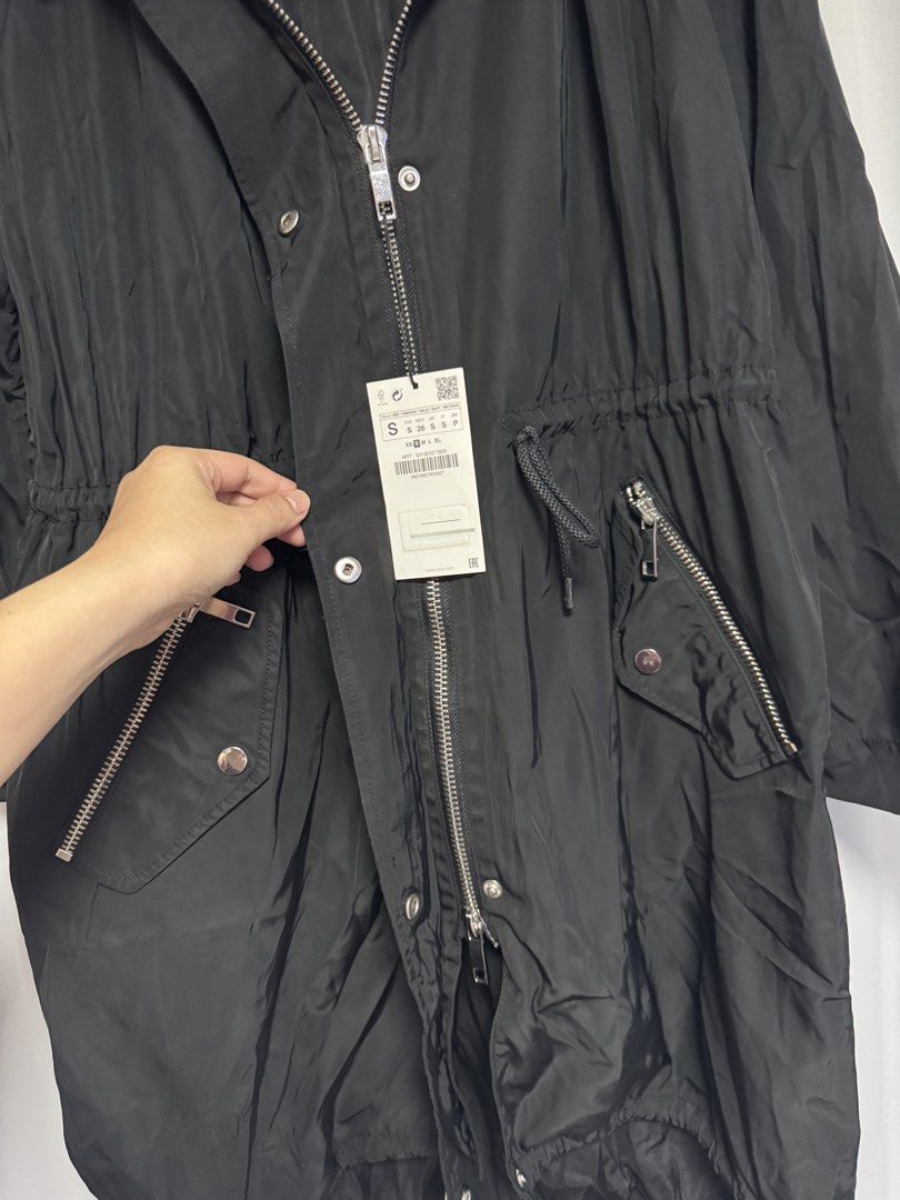 Zara Basic Black Water Repellent Hooded Parka Jacket (Category: Coats, Jackets and Outerwear) located in Calamba. Submitted by cheriiv (Listing ID 1469776286, Image 3). Description: - Brand: Zara Basic - Color: Black - Condition: Brand new with original tags attached - Material: Water-repellent fabric - Features: Attached hood, adjustable drawstring waist for a custom fit, front zipper pockets - Closure: Full front zipper with snap button storm f