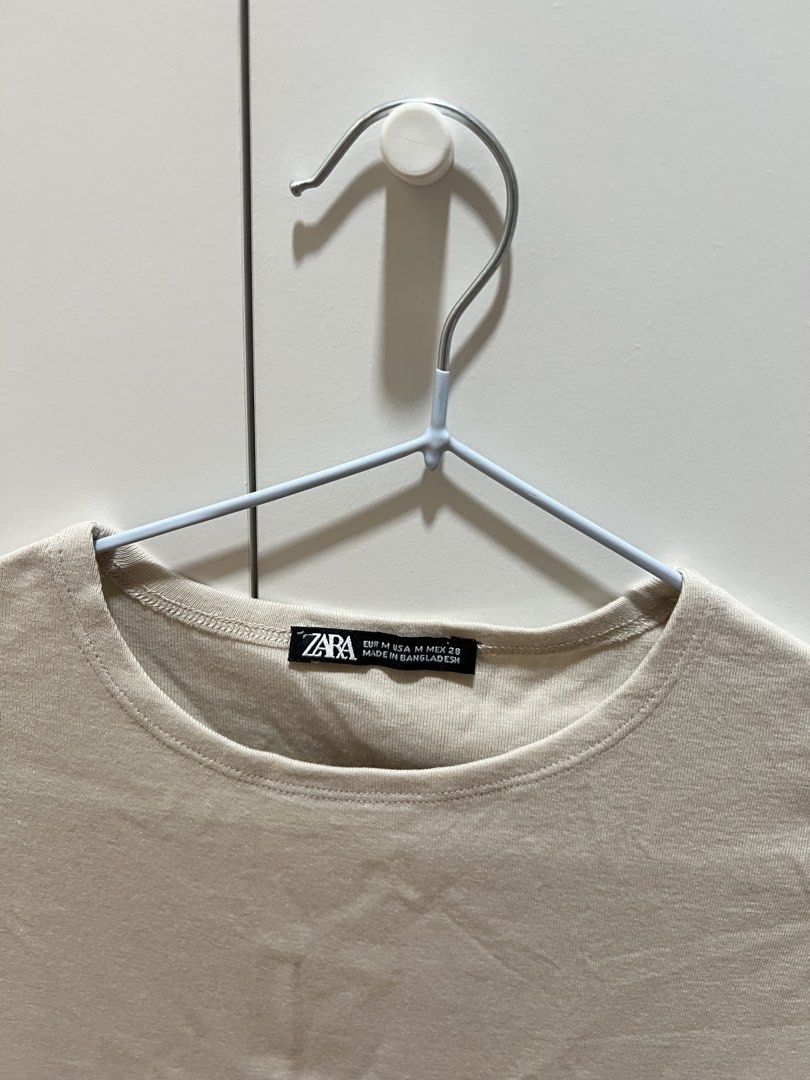 [Zara] Beige Seamless Crop Top (Category: Blouses) located in Muntinlupa City. Submitted by shopblank (Listing ID 1469890299, Image 2). Description: - Brand: Zara - Size: M (fits S-M) - Color: Neutral beige - Material: Soft stretch cotton - Design: Short cap sleeves, round neckline, cropped length - Condition: Worn a few times, still in great shape - Style tip: Perfect for pairing with high-waisted jeans or skirts.