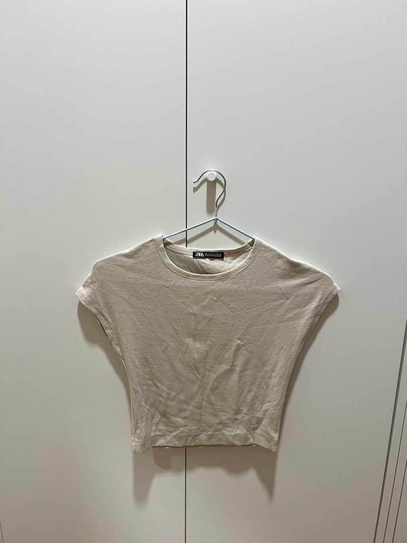 [Zara] Beige Seamless Crop Top (Category: Blouses) located in Muntinlupa City. Submitted by shopblank (Listing ID 1469890299, Image 1). Description: - Brand: Zara - Size: M (fits S-M) - Color: Neutral beige - Material: Soft stretch cotton - Design: Short cap sleeves, round neckline, cropped length - Condition: Worn a few times, still in great shape - Style tip: Perfect for pairing with high-waisted jeans or skirts.