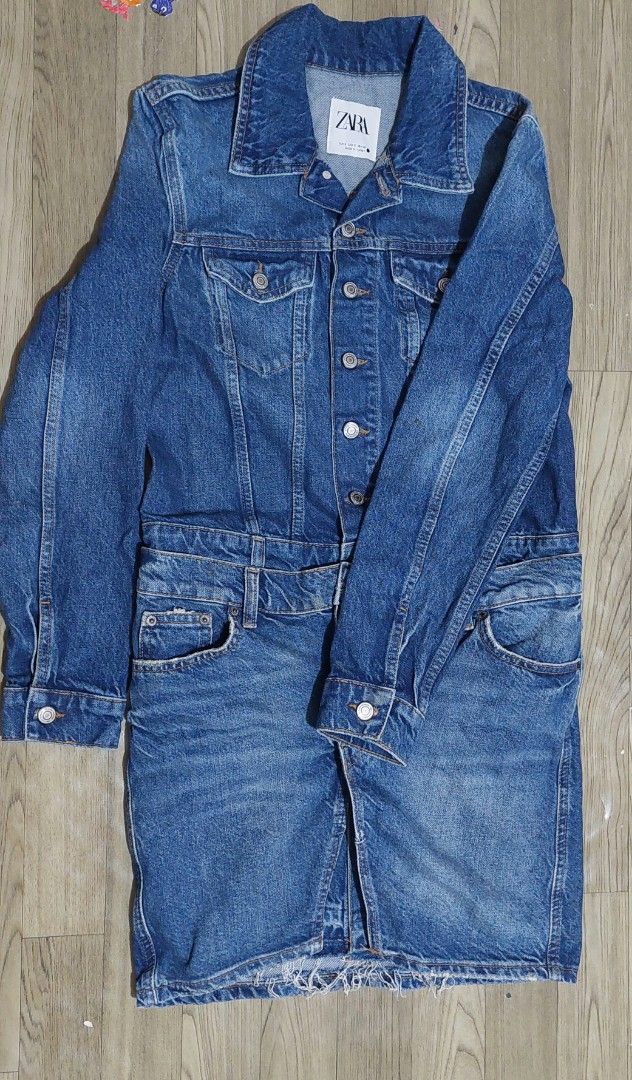 Zara Denim Dress Size S (Category: Dresses) located in Taguig. Submitted by thrifthub.ph (Listing ID 1469788705, Image 3). Description: - Brand: Zara - Size: S - Material/Origin: Made in Turkey - Design: Blue denim mini dress combining a jean jacket top with a skirt bottom - Details: Button-up front with metal buttons, chest pockets, and functional side pockets - Hem: Trendy raw frayed hem - Condition: Excellent.