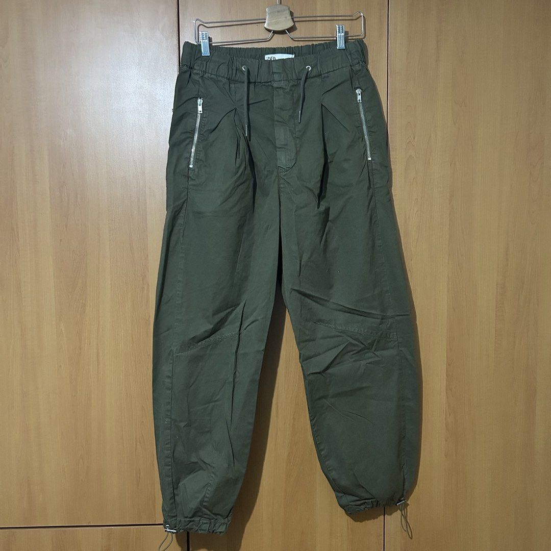 Zara Olive Green Cargo Pants (Category: Jeans) located in Mandaluyong City. Submitted by vwonu (Listing ID 1469865112, Image 1). Description: - Waist: 32-34 inches, stretchable elastic with adjustable drawstring - Length: 41 inches - Brand/Model: Zara Cargo Pants - Color: Olive green - Size: M (EUR M / US M / MEX 28) - Pockets: Secure zipped pockets near hips and back patch pockets - Hems: Adjustable drawstrings at the ankles .