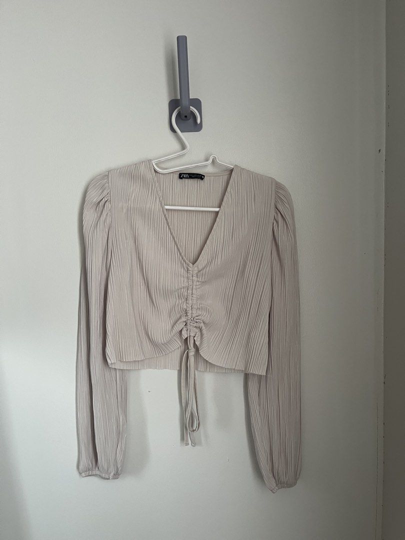 Zara Ruched Top (Category: Longsleeves) located in Lapu Lapu. Submitted by alexisdeclutters (Listing ID 1469787092, Image 1). Description: - Brand: Zara - Color: Beige - Size: S - Design: All-over pleats, V-neckline with adjustable drawstring tie - Details: Long sleeves with gathered cuffs, cropped fit - Condition: Brand new with tag attached.