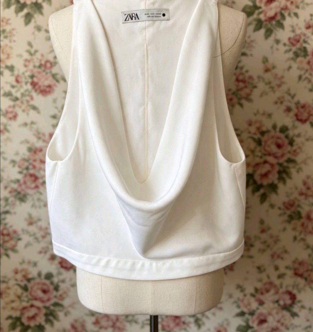 Zara White Cowl Neck Crop Top (Category: Sleeveless) located in Manila. Submitted by charlottej01596 (Listing ID 1469793676, Image 1). Description: - Brand: Zara - Color: Clean White - Style: Sleeveless semi crop top with draped cowl neckline - Details: Structured folds at front and back, wide finished hem - Condition: Excellent, lightweight fabric with clean tag, no stains or pulls.