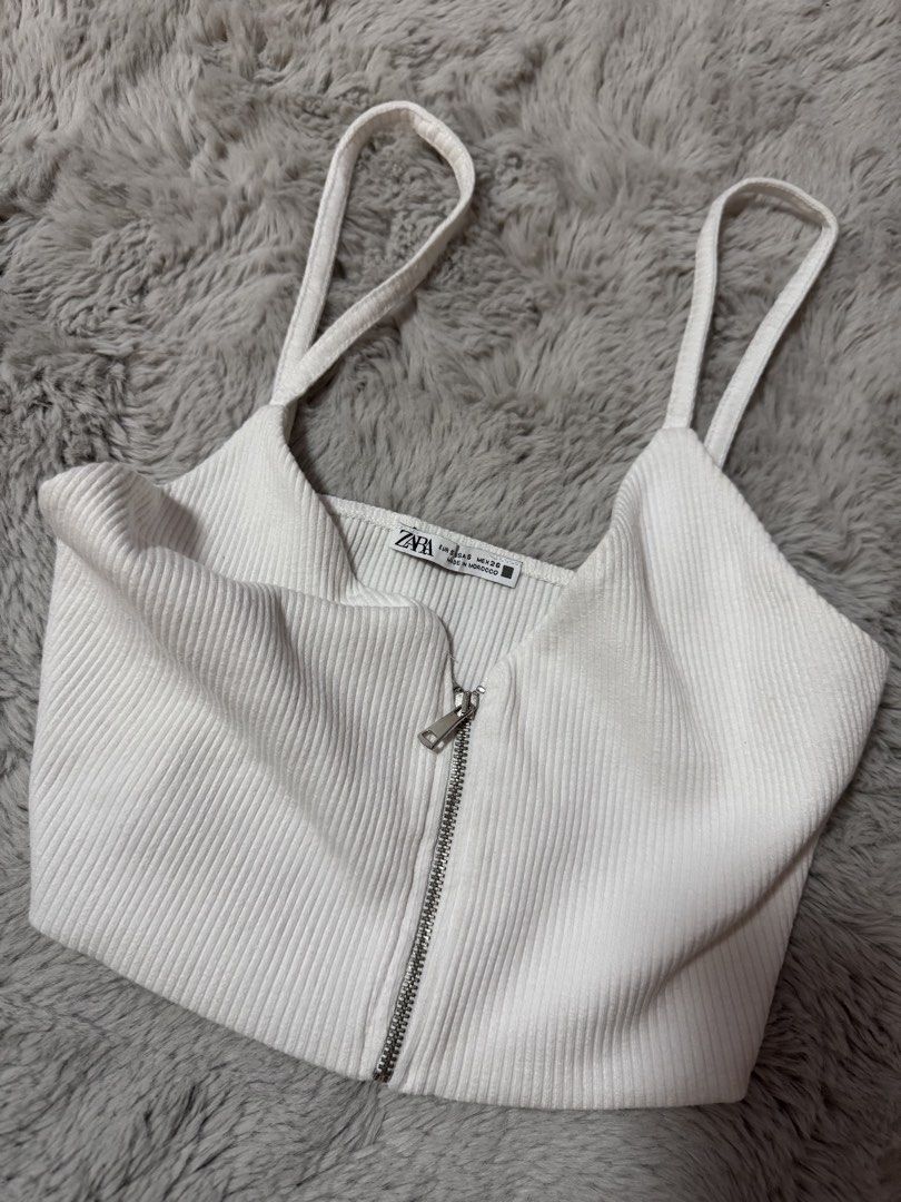 Zara White Ribbed Zip-Front Crop Top (Category: Sleeveless) located in Calamba. Submitted by cheriiv (Listing ID 1469886156, Image 2). Description: - Brand: Zara - Size: S - Color: White - Material: Soft, stretchy ribbed knit - Features: Deep V-neckline, front metal zipper, thin spaghetti straps.