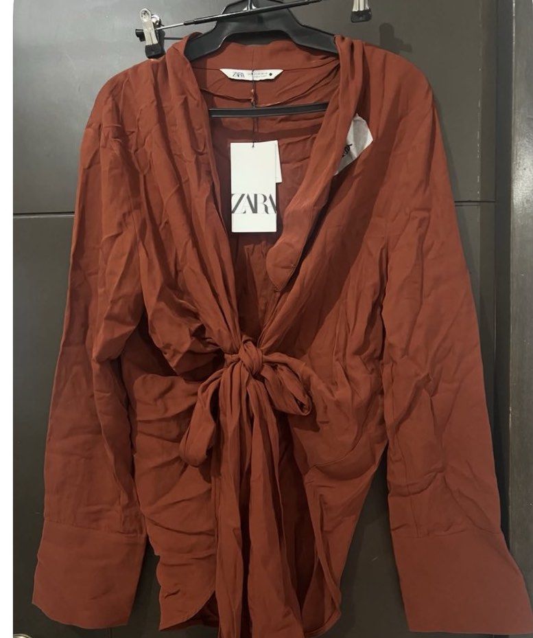 Zara wrap around top M-L (Category: Blouses) located in Manila. Submitted by viadinamama143 (Listing ID 1469813557, Image 1). Description: - Brand: Zara - Style: Wrap-around top with front tie detail - Color: Terracotta brown - Size: Medium to Large - Features: Long sleeves with wide cuffs - Condition: Brand new with original tags attached, never worn (has minor storage wrinkles).