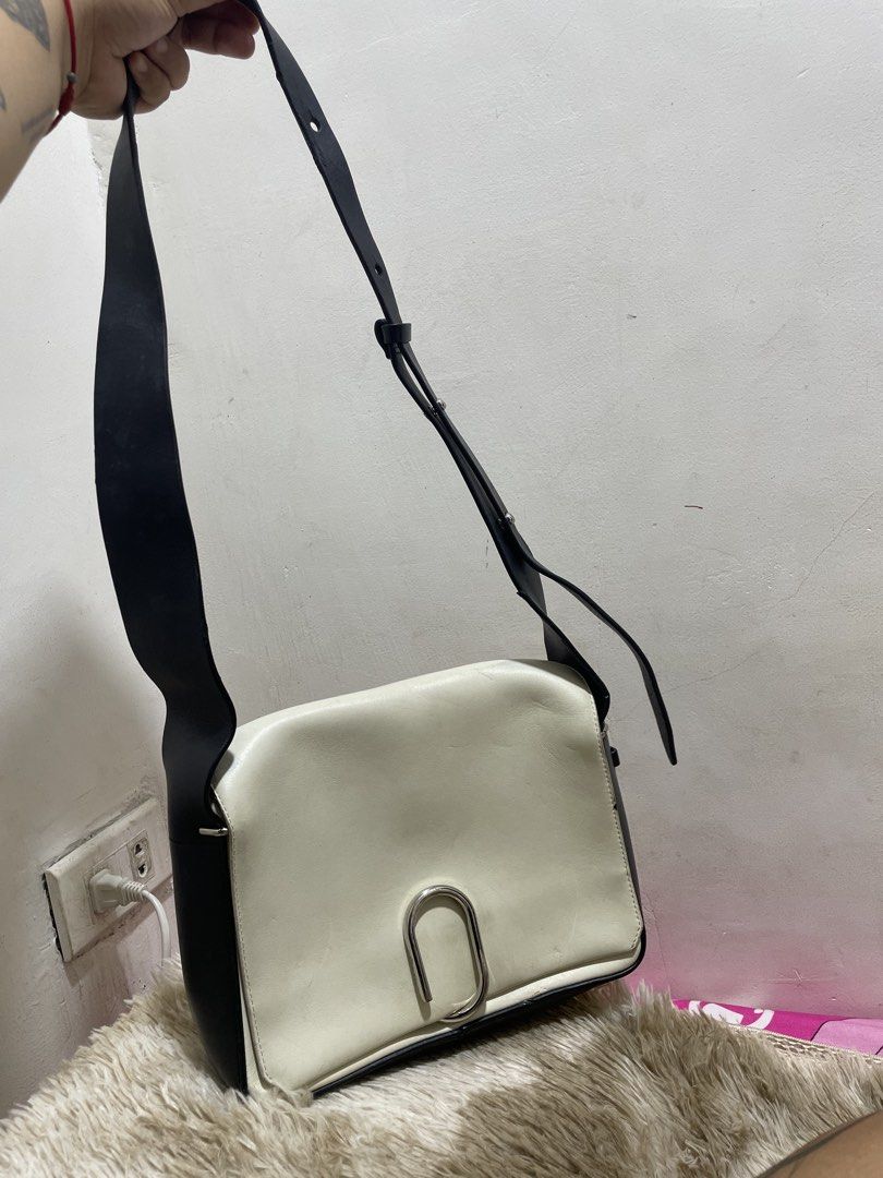3.1 Phillip Lim White and Black Shoulder Bag (Category: Cross-body Bags) located in Santiago. Submitted by UkayLuxxSelector (Listing ID 1470090894, Image 1). Description: - Brand: 3.1 Phillip Lim - Color: White and black leather - Hardware: Silver-tone with front lock closure - Strap: Adjustable black strap on sides - Interior: White leather lining with a zipped pocket and gold-stamped logo - Shipping: Via J&T or LBC (Buyer bears shipping fee).