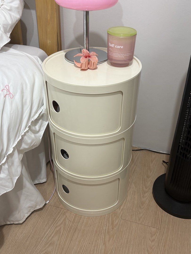 3-tier round plastic bedside storage cabinet drawers (Category: Shelves, Cabinets & Racks) located in Binan City. Submitted by andreagailaputen (Listing ID 1469992108, Image 1). Description: - Color: Cream white - Design: 3-tier round plastic storage cabinet with sliding drawers and cute circular cut-out handles - Condition: Good overall, with some coffee mug ring stains on the top surface - Function: Compact bedside or desk unit, ideal for organ