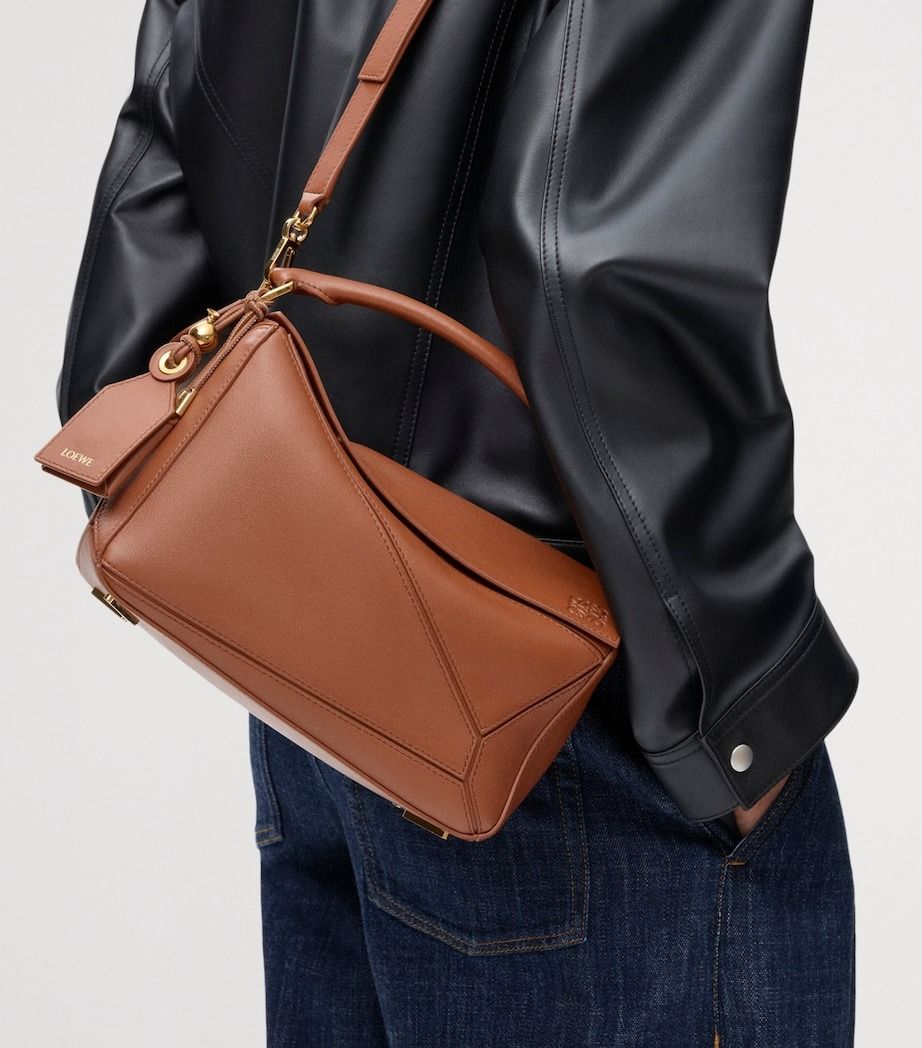 💜 LOEWE Medium Leather Featherlight Puzzle Top-Handle Bag (Category: Luxury Bags & Wallets) located in Lala. Submitted by mohsin0825 (Listing ID 1470034250, Image 2). Description: LOEWE Medium Leather Featherlight Puzzle Top-Handle Bag 17,990p pl7s sf Like new/ Brandnew shoulder or crossbody carry detachable and adjustable strap with rotating dogclips zip closure with articulated pull detachable LOEWE embossed tag with secret pocket and balloon 