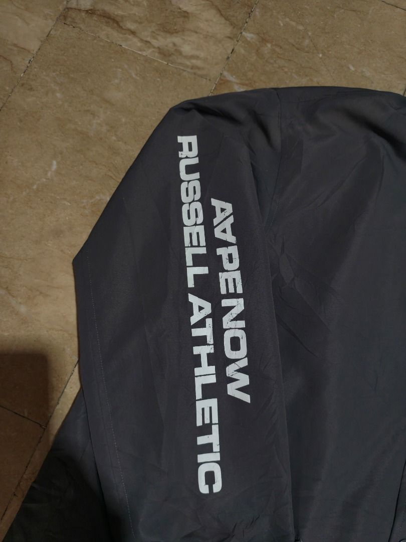 A Bathing Ape x Russell Athletic Coach Jacket (Category: Coats, Jackets and Outerwear) located in Santa Rosa. Submitted by izxenjairr80094 (Listing ID 1469999185, Image 2). Description: - Brand/Collab: Bape x Russell Athletic - Item: Dark grey nylon coach jacket - Size: Medium - Details: Dual brand logos on the chest, text graphic on the right sleeve - Closure & Fit: Snap button closure with an adjustable drawstring hem - Condition: Excellent - i