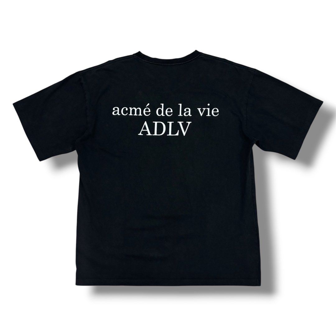 acmé de la vie ADLV Black T-Shirt (Category: Shirts) located in Quezon City. Submitted by grailph (Listing ID 1470064310, Image 1). Description: - Brand: acmé de la vie (ADLV) - Color: Black with white typography - Size: 2 - Dimensions: 24”x29” - Design: Small front chest logo, large graphic print across back shoulders - Fit: Standard crew neck, short sleeves - Material: Solid cotton fabric - Style: Classic streetwear, highly versatile for casual