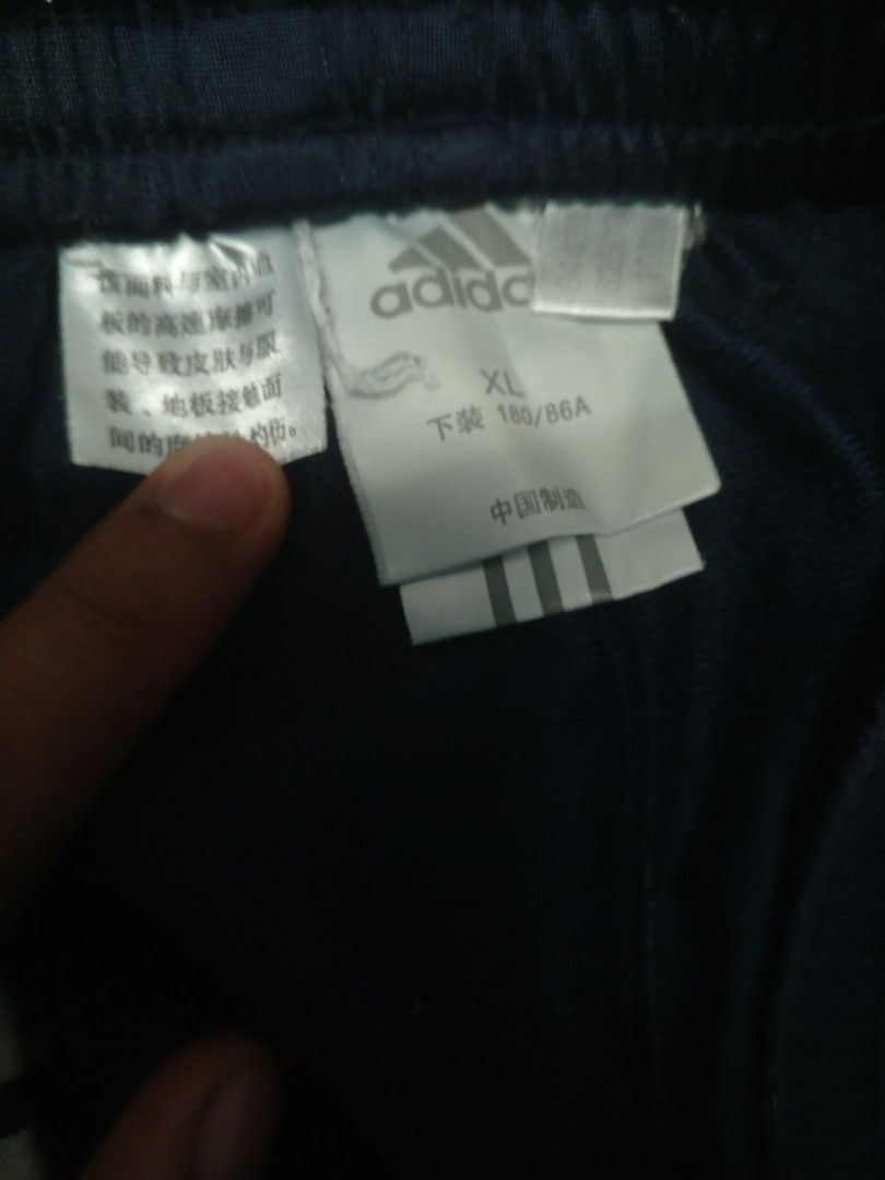 Adidas Baggy Track Pants (Category: Joggers) located in Manila. Submitted by heavenlyclo05 (Listing ID 1470000961, Image 2). Description: ADIDAS TRACK PANTS Size: XL Width: 36 - 42 Length: 42.5 Hem: 11 Very Good Condition No issue Claim📩📩 - Brand: Adidas - Color: Navy blue with white side stripes and red cuff accents - Size: XL - Fit: Relaxed fit with a comfortable elastic waistband - Features: Secure zippered pockets on both sides - Condition:
