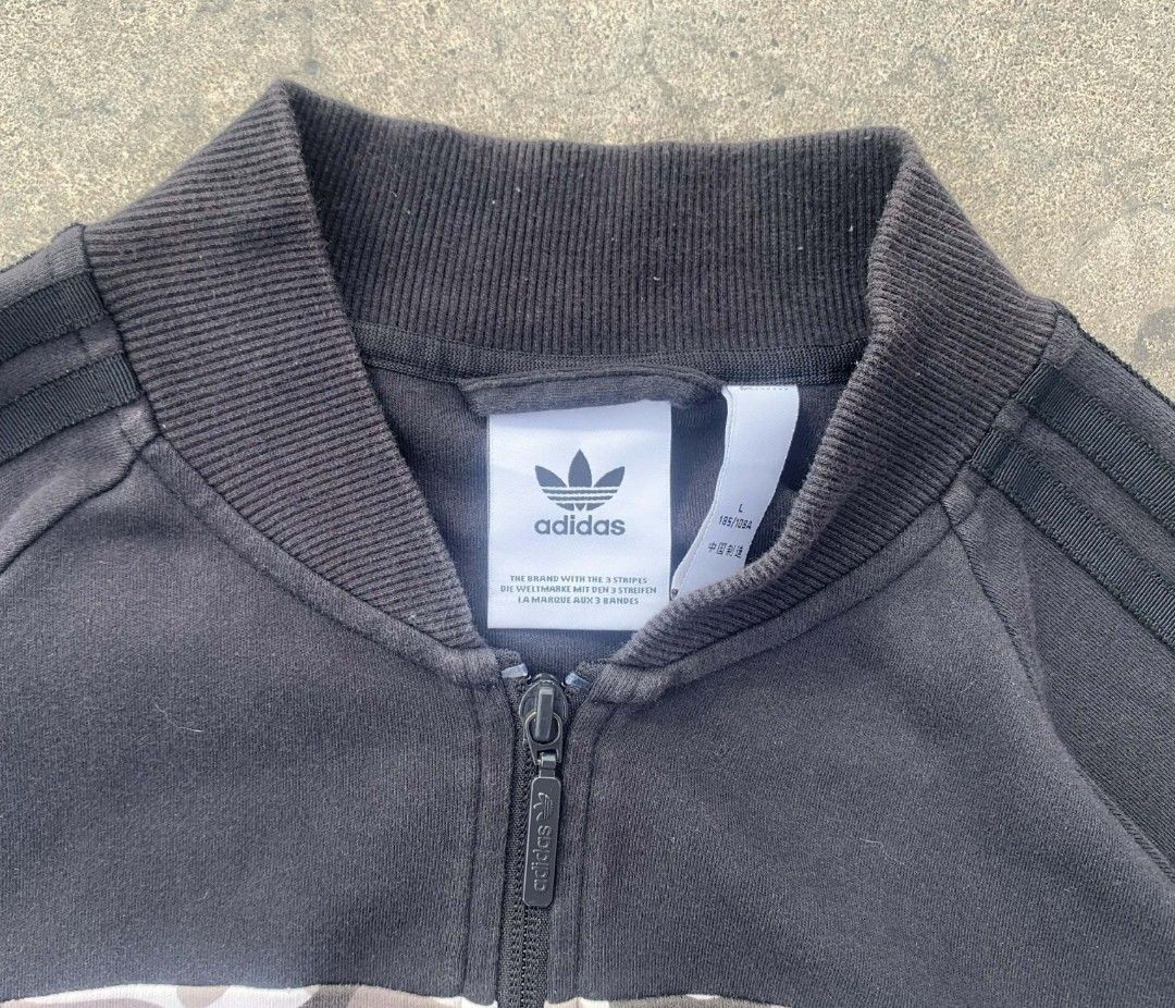 Adidas Camo Block Track Jacket Size L (Category: Coats, Jackets and Outerwear) located in Caloocan City. Submitted by holygems (Listing ID 1470079736, Image 3). Description: - Brand: Adidas - Style: Black track jacket with camo chest panel and large camo trefoil back logo - Size: L - Features: Full zip closure, dual front pockets, ribbed collar, cuffs, and hem - Condition: Excellent streetwear piece, sporty and comfortable - Meet-ups and shipping