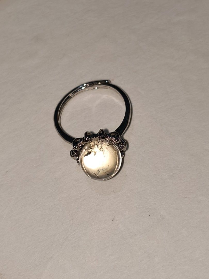 Adjustable silver ring with Clear Quartz sphere stone (Category: Rings) located in Caloocan City. Submitted by books_and_beads (Listing ID 1470090371, Image 2). Description: A beautiful, minimalist statement piece featuring a polished Clear Quartz cabochon. The domed stone has a gorgeous, glassy clarity with natural 'ice crack' inclusions that catch and reflect the light beautifully. It is set in a detailed, vintage-inspired silver-tone crown set