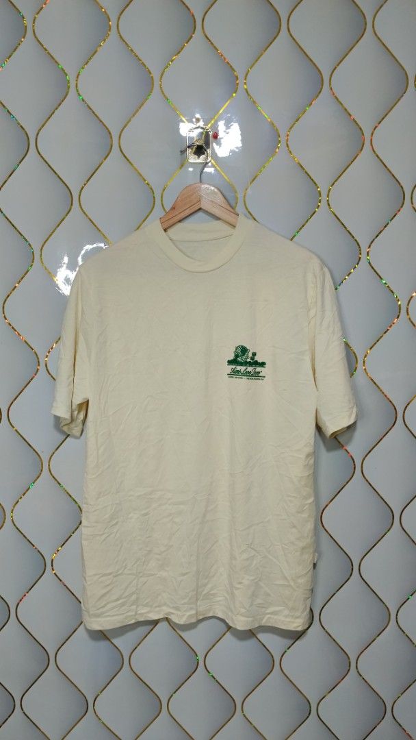Aimé Leon Dore Queens World's Borough Tee (Category: Tshirts & Polo Shirts ) located in Manila. Submitted by zariyah.1986 (Listing ID 1469950106, Image 1). Description: - Brand: Aimé Leon Dore - Color: Cream with green graphic print - Design: Small chest logo and large back graphic featuring the Queens Unisphere and landmarks - Details: Crew neck, short sleeves, clean collar - Measurements: 21.5 inches pit to pit, 28.5 inches length - Condition: 