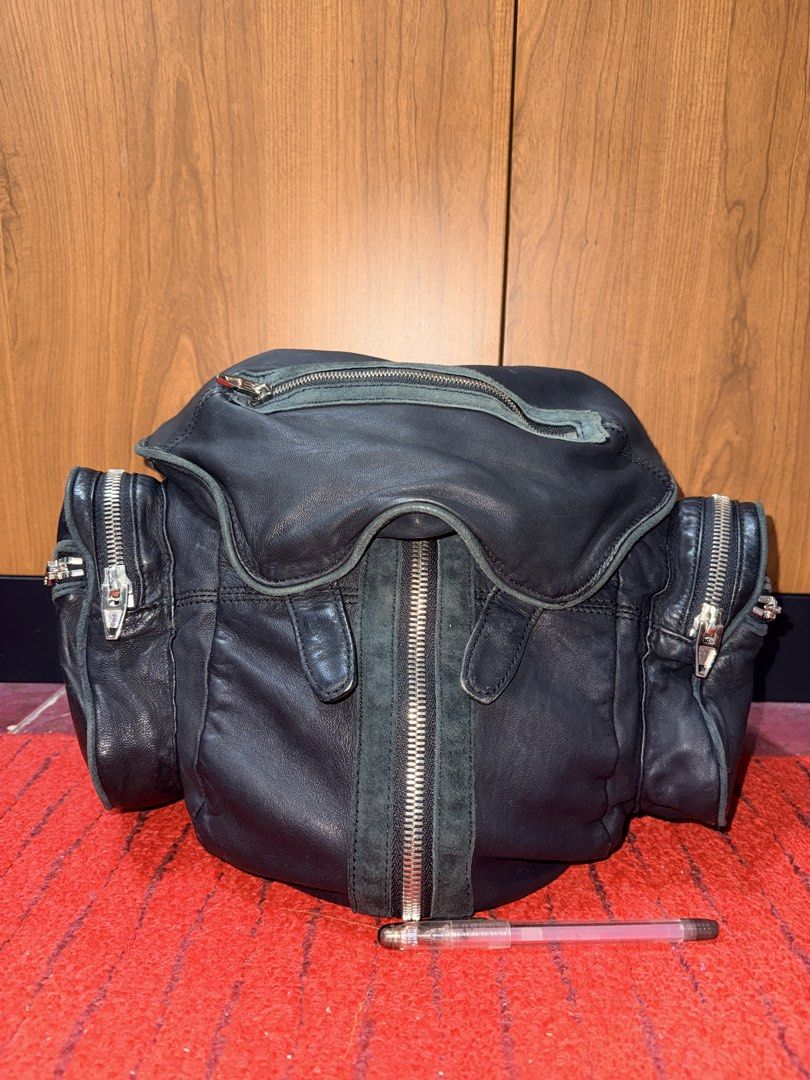 Alexander Wang-Style Marti Multi-Zip Backpack – Black (Category: Backpacks) located in Davao. Submitted by rebaggedph (Listing ID 1469989429, Image 1). Description: Edgy, statement-making black backpack with the signature multi-zipper look inspired by Alexander Wang’s Marti design. A versatile piece for everyday wear, travel, or street-style outfits. Features * Black leather-like exterior with contrasting grey-green suede-like trim * Multiple sil