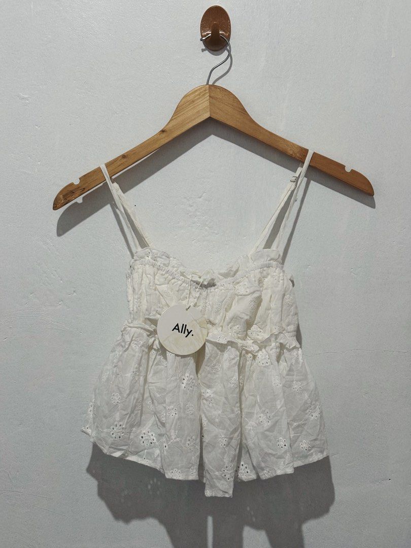 ALLY WHITE EYELET SPAGHETTI STRAP CROP TOP (Category: Sleeveless) located in Angeles City. Submitted by chic.haven (Listing ID 1470039407, Image 1). Description: - Brand: Ally (Tag still attached) - Color: Classic white - Details: Delicate all-over eyelet embroidery, thin spaghetti straps, ruffled hem, and smocked bust - Condition: Brand new - Style Tip: Great for summer, easily pairs with denim shorts or skirts.