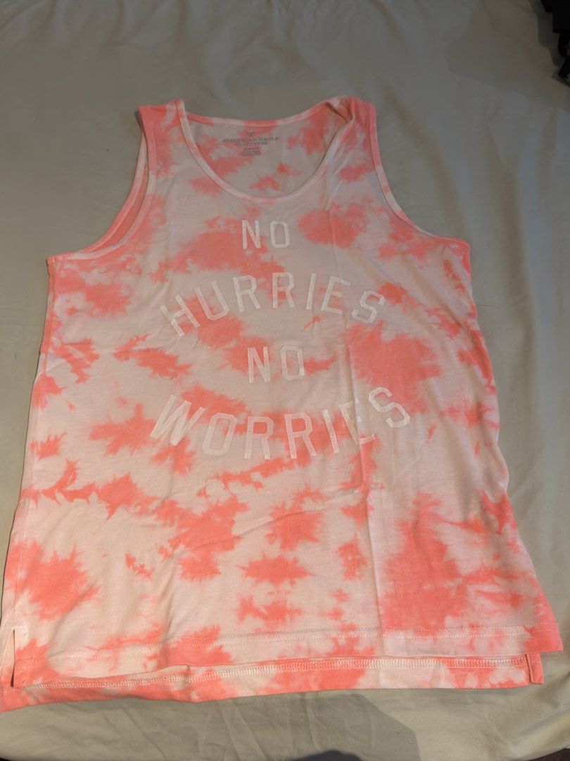 American Eagle Tank Top Sando sleeveless (Category: Tshirts & Polo Shirts ) located in Binan City. Submitted by cody29 (Listing ID 1470051402, Image 1). Description: - Brand: American Eagle - Size: XS 230 EACH - Color/Pattern: White and pink tie-dye all over - Design: 'NO HURRIES NO WORRIES' text on the front - Material: Cotton and polyester blend (lightweight & breathable) - Fit: Relaxed fit, ideal for warm weather or layering - Condition: Inclu