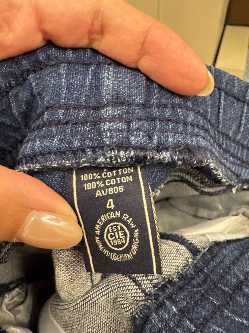 American Raw Denim Shorts Size 4 (Category: Babies & Kids Fashion) located in Manila. Submitted by __nix (Listing ID 1470018099, Image 3). Description: - Size: 4 - Material: 100% cotton raw denim - Color: Dark blue with grey contrast panels on sides, back yoke, and pocket - Waistband: Elastic with adjustable drawstring - Hem: Rolled cuffs - Style: Casual, perfect for everyday wear.