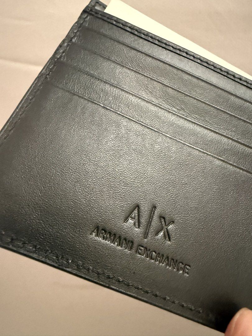 Armani Exchange Black Leather Bi-fold Wallet (Category: Wallets & Card Holders) located in Bacoor. Submitted by ciaobellissimaph (Listing ID 1469976519, Image 3). Description: - Brand: Armani Exchange - Material: Genuine black leather - Condition: Brand new, never used, with original packaging inserts - Design: Minimalist exterior with silver stamped logo - Interior: Multiple card slots and secure snap-closure coin pocket - Quality: Clean stitchi