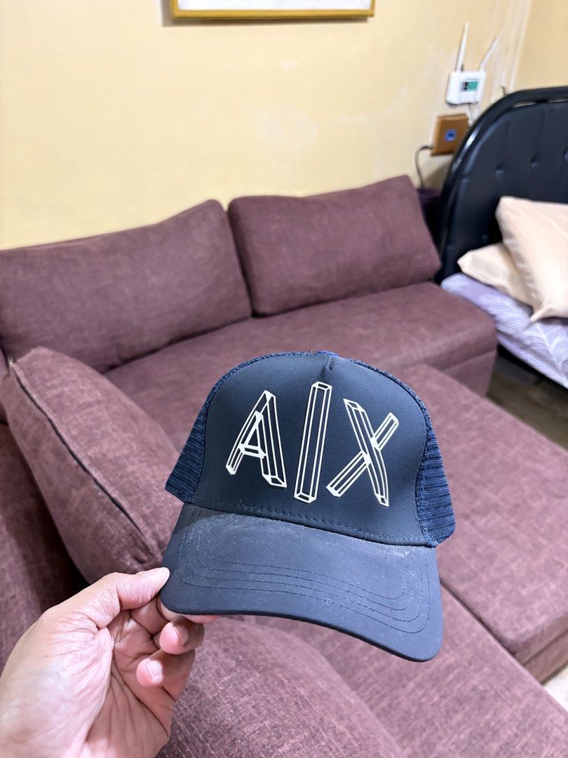 Armani Exchange Trucker Cap Blue A|X Logo Snapback Hat (Category: Caps & Hats) located in Manila. Submitted by breezy09breezy (Listing ID 1469990044, Image 1). Description: - Brand: Armani Exchange - Color: Dark Navy Blue with bold raised white A|X logo - Style: Classic trucker cap with breathable mesh back panels - Fit: Adjustable plastic snapback closure for a customized fit - Details: Features a brown leather logo patch above the back strap an