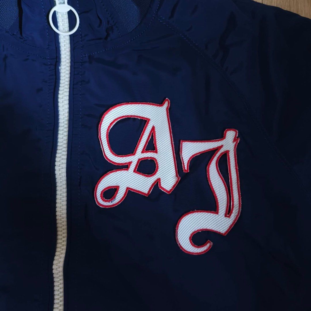 Armani Jeans Navy Blue Bomber Jacket Size XS (Category: Coats, Jackets and Outerwear) located in Baguio. Submitted by gab_thrift (Listing ID 1470090782, Image 3). Description: - Brand: Armani Jeans - Style: Navy blue bomber jacket with striking red inner lining - Details: Bold white and red AJ embroidered patch on the chest - Hardware: Full zip closure with dual pullers - Trims: Ribbed collar, cuffs, and hem with sporty red and white striping - S