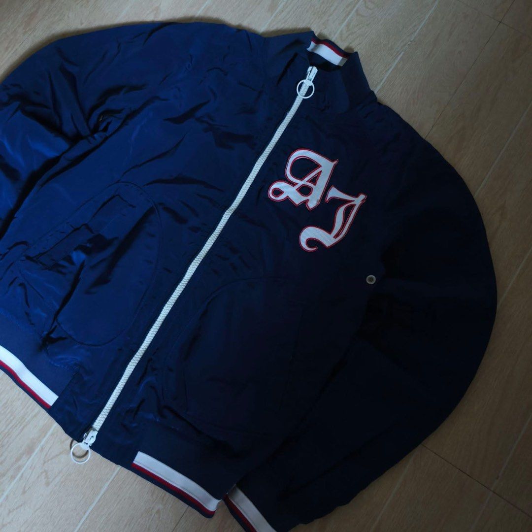 Armani Jeans Navy Blue Bomber Jacket Size XS (Category: Coats, Jackets and Outerwear) located in Baguio. Submitted by gab_thrift (Listing ID 1470090782, Image 2). Description: - Brand: Armani Jeans - Style: Navy blue bomber jacket with striking red inner lining - Details: Bold white and red AJ embroidered patch on the chest - Hardware: Full zip closure with dual pullers - Trims: Ribbed collar, cuffs, and hem with sporty red and white striping - S