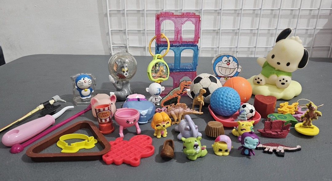 Assorted Toys Figures and Miniatures Lot (Category: Kids Toys) located in San Jose del Monte. Submitted by stellarbeauty (Listing ID 1470080058, Image 1). Description: - Mixed pile of random toys sold as a bundle only - Includes Doraemon figures, Tom and Jerry in a globe, mini dinosaurs, Shopkins, translucent building blocks, soccer balls, and a Pochacco figure - Made of various materials like plastic and rubber in different sizes - Perfect for c