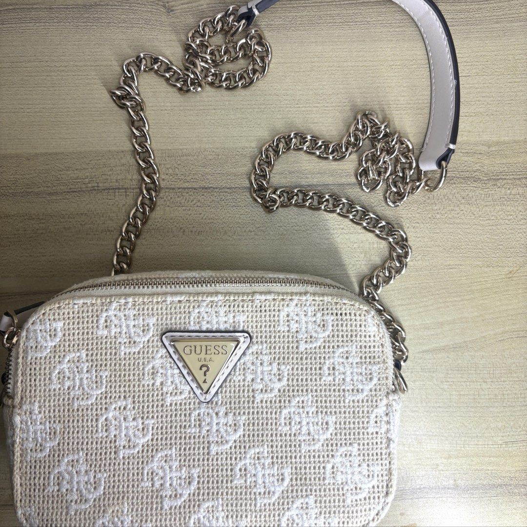 Authentic Guess White Crossbody Bag with Chain Strap (Category: Cross-body Bags) located in Angeles City. Submitted by muse_archive (Listing ID 1470047706, Image 1). Description: - Authentic Guess crossbody bag with iconic monogram pattern - with gold chain strap - with original Guess dust bag -No issues, no stains, the gold hardware is good as new. Used once lang! -Bought it for 7k+, selling it for 3k.