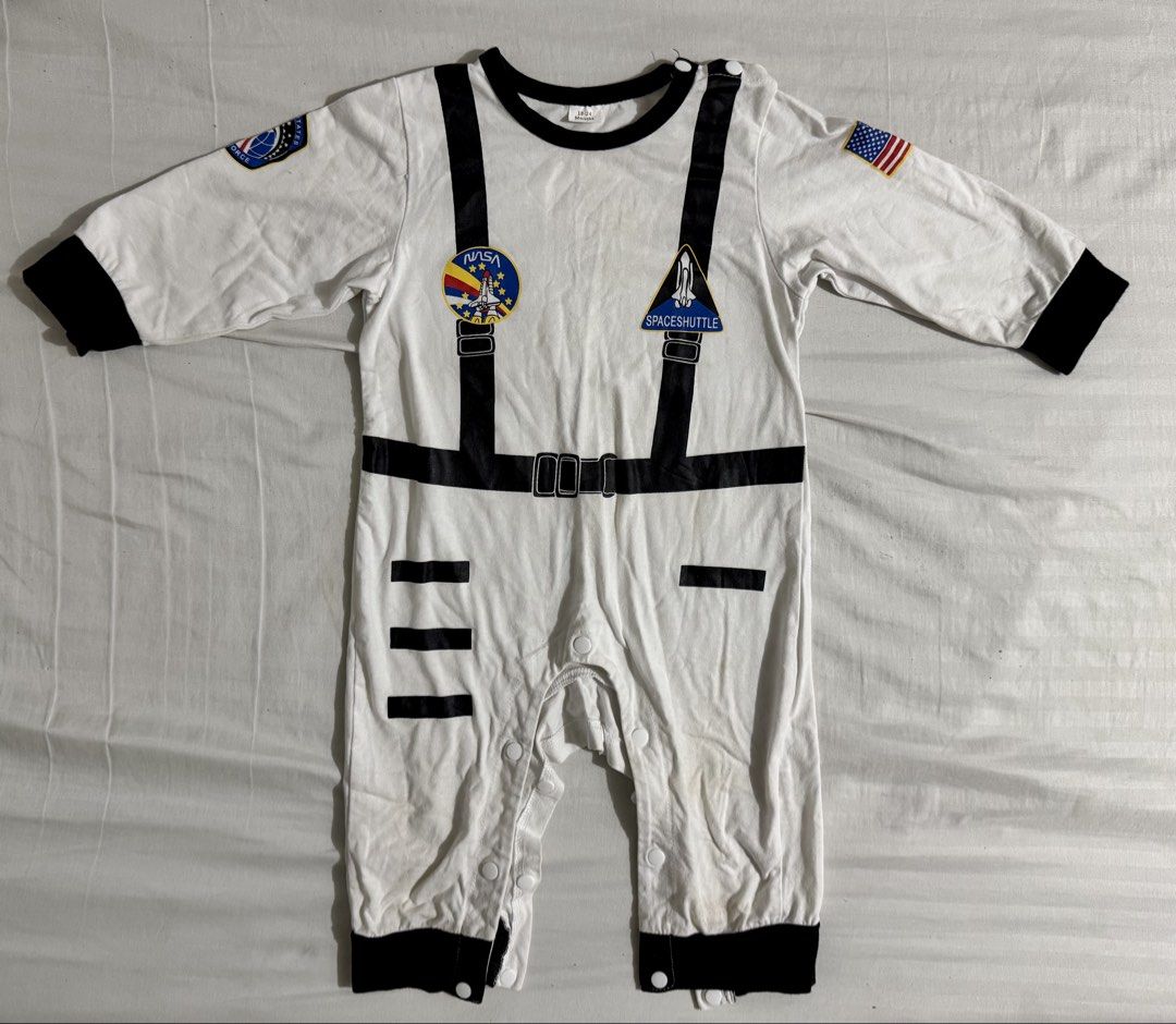 Baby Astronaut Costume (Category: Babies & Kids Fashion) located in Paranaque City. Submitted by april_anythingpreloved (Listing ID 1470097712, Image 1). Description: - Size: 18-24 months (worn only once by my son on his 1st birthday) - Material: Comfortable cotton blend - Design: White with black trim, NASA and space shuttle patches, US flag print - Features: Shoulder and crotch snap buttons for easy dressing and diaper changes - Perfect for: Dr