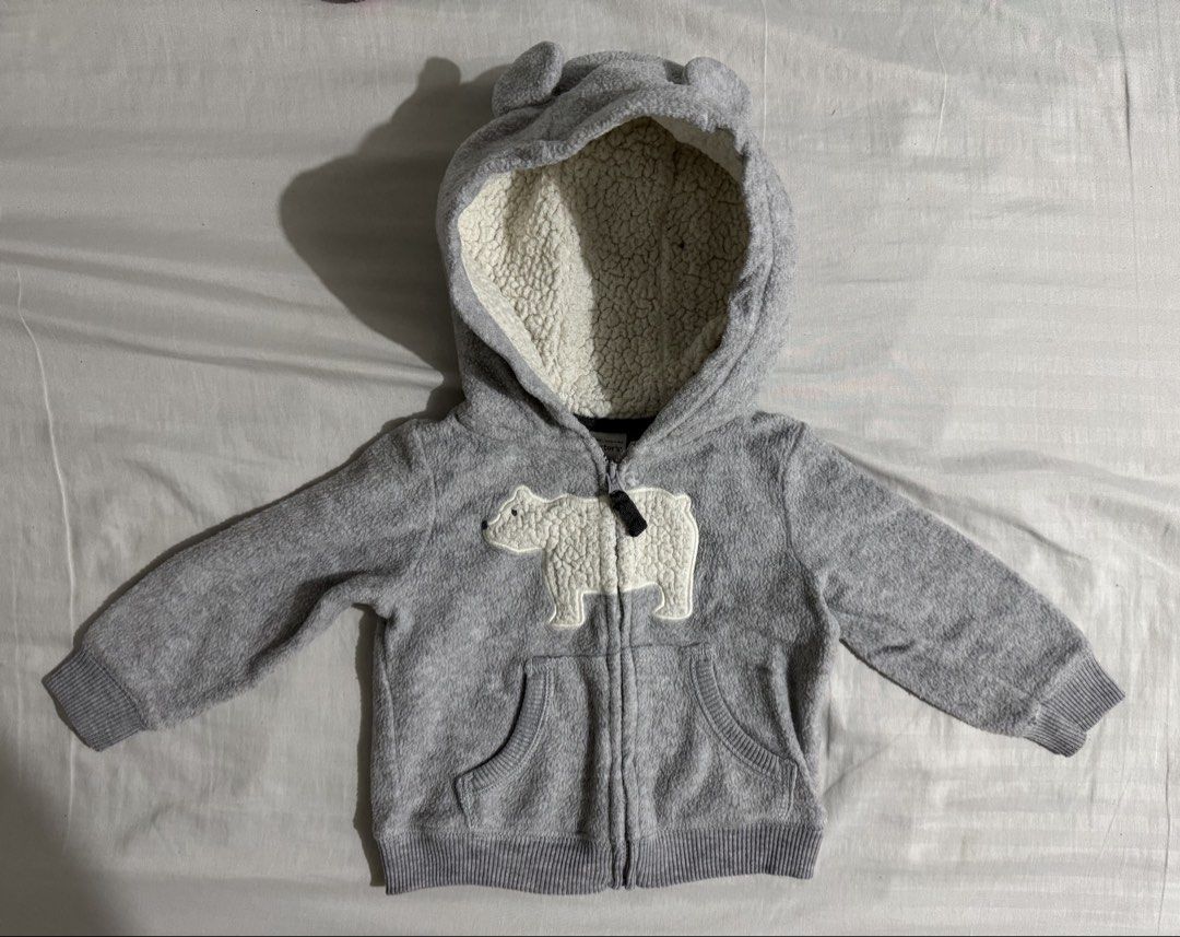 Baby Jacket (Category: Babies & Kids Fashion) located in Paranaque City. Submitted by april_anythingpreloved (Listing ID 1470094495, Image 1). Description: - Brand: Carter's - Color: Grey - Material: Soft fleece all over with cozy sherpa hood lining - Design: Cute polar bear applique on the chest and playful bear ears on the hood - Features: Full zip-up closure, two front pockets, and ribbed cuffs and hem - Condition: Brand new - Perfect for keep