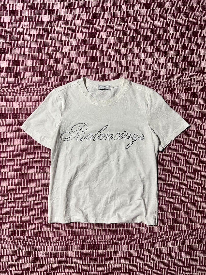 Balenciaga White Rhinestone Script Logo T-Shirt Size M (Category: Shirts) located in Manila. Submitted by wardrobeph.com (Listing ID 1470124683, Image 1). Description: - Authentic Balenciaga white t-shirt - Eye-catching rhinestone brand logo across the chest - Size: M (tag inside collar) - Classic crew neck and short sleeves - Clean overall condition with minor wrinkles from storage - Long care label attached at inner side seam.