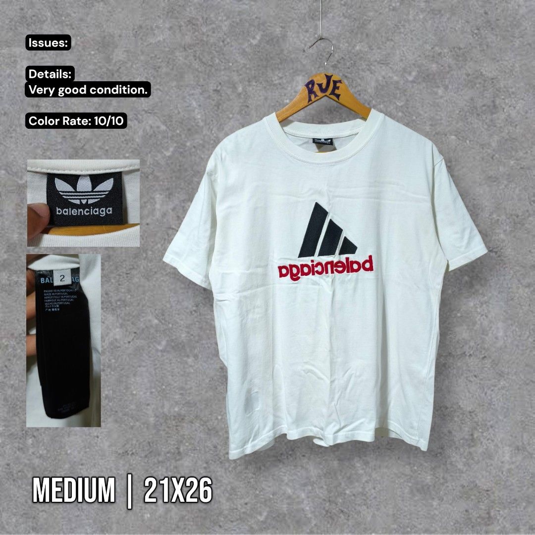 Balenciaga x Adidas White Tee (Category: Luxury Apparel) located in Bayambang. Submitted by rajuergui76226 (Listing ID 1470009388, Image 1). Description: - Authentic Balenciaga x Adidas Collaboration Tee - Color: Crisp White - Size: 2 (Measurements: 21" width x 26" length) - Design: Classic trefoil logo with unique upside-down branding print on the chest - Material: Premium cotton, Made in Portugal - Condition: Flawless, pristine condition - Mode