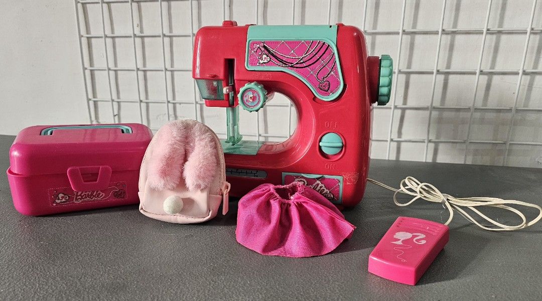 Barbie Toy Sewing Machine Set with Accessories (Category: Kids Toys) located in San Jose del Monte. Submitted by stellarbeauty (Listing ID 1470025107, Image 1). Description: - Pink and turquoise Barbie toy sewing machine - Includes matching storage box, mini fluffy pink backpack, and small fabric skirt - Clean item with minimal wear, great for kids who love crafts and fashion.