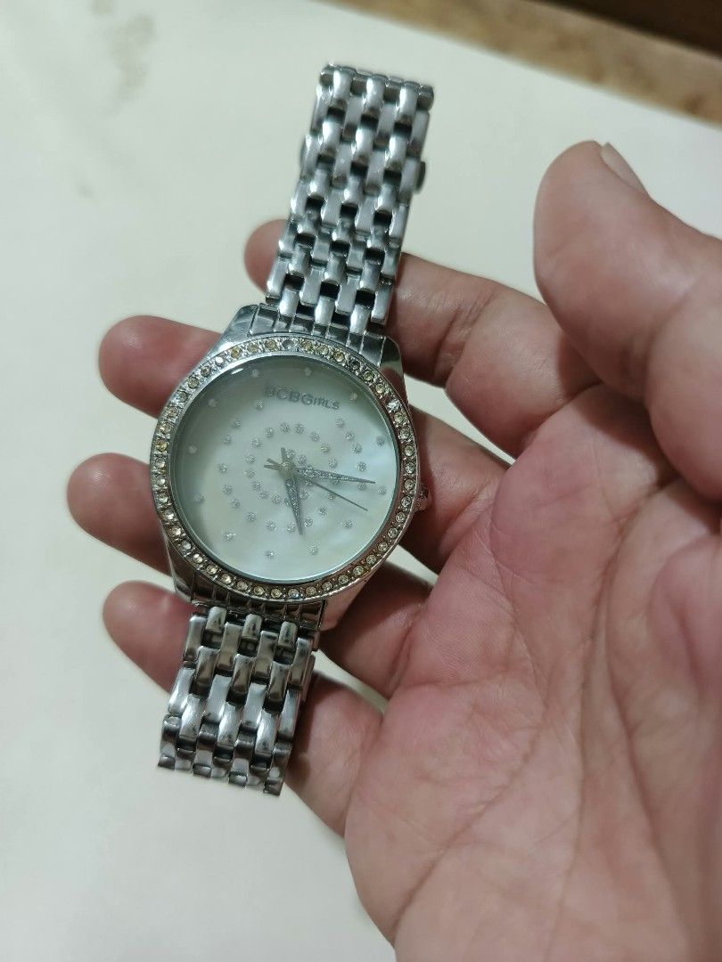 BCBGGirls Silver Tone Rhinestone Watch (Category: Women's Watches) located in Abucay. Submitted by thrifty.picked (Listing ID 1470123624, Image 1). Description: - Brand: BCBGGirls - Color: Silver tone - Dial: Mother of pearl covered in rhinestone details with a sparkling crystal bezel - Closure: Link bracelet with fold-over clasp - Features: Stainless steel back, water resistant, Japan movement - Condition: Minor wear on the metal surface.