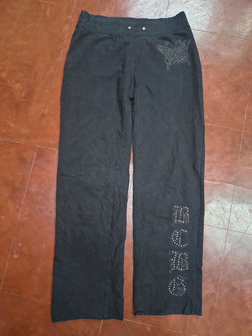 BCBGMAXAZRIA Black Rhinestone Embellished Sweatpants (Category: Jeans) located in Bani. Submitted by ger.0 (Listing ID 1470085796, Image 1). Description: - Brand: BCBGMAXAZRIA - Color: Black - Design: Rhinestone butterfly graphic on the hip and rhinestone lettering down the leg - Waistband: Elastic with drawstring grommets - Material: Soft, high-quality cotton - Fit: Easy pull-on style, super comfortable for lounging or casual wear.