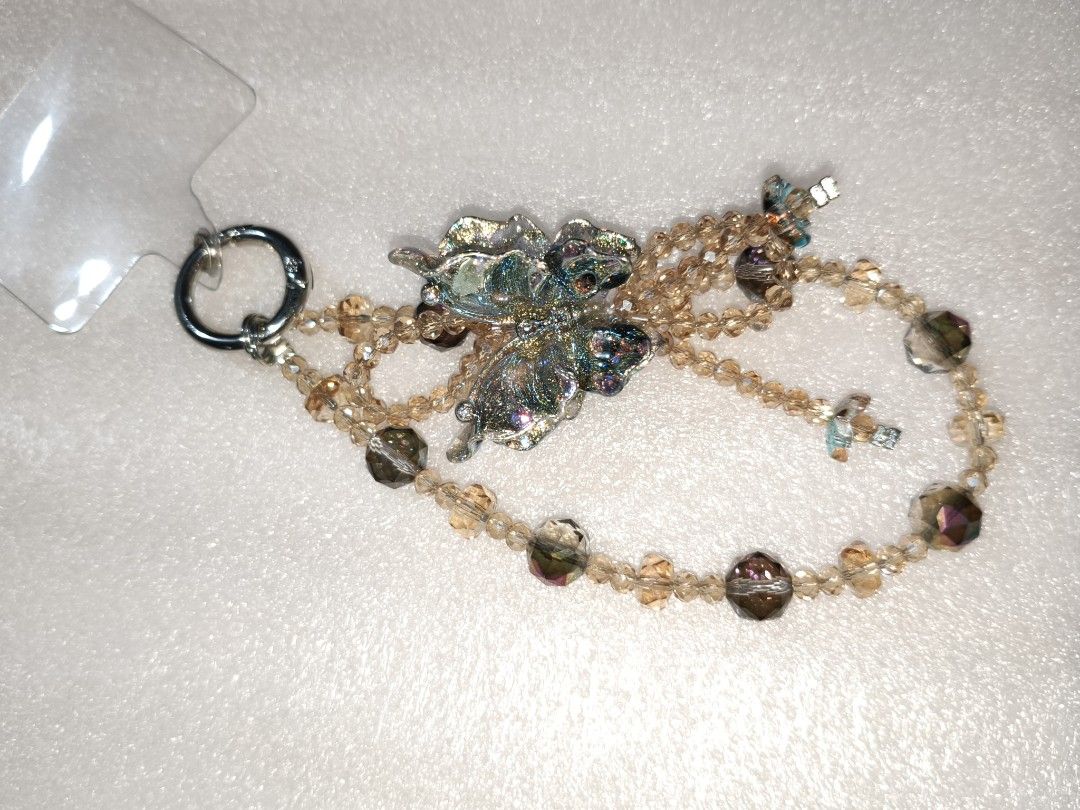 Beaded Phone Charm Strap Wristlet Handcrafted (Category: Handmade Craft) located in Caloocan City. Submitted by books_and_beads (Listing ID 1470081215, Image 3). Description: - Handmade beaded phone charms with crystal beads, pearls, and cute butterfly or flower accents - Durable design featuring secure metal rings and sturdy multi-strand beadwork - Versatile accessory that can be attached to phones, bags, or keys - Multiple color combinations av