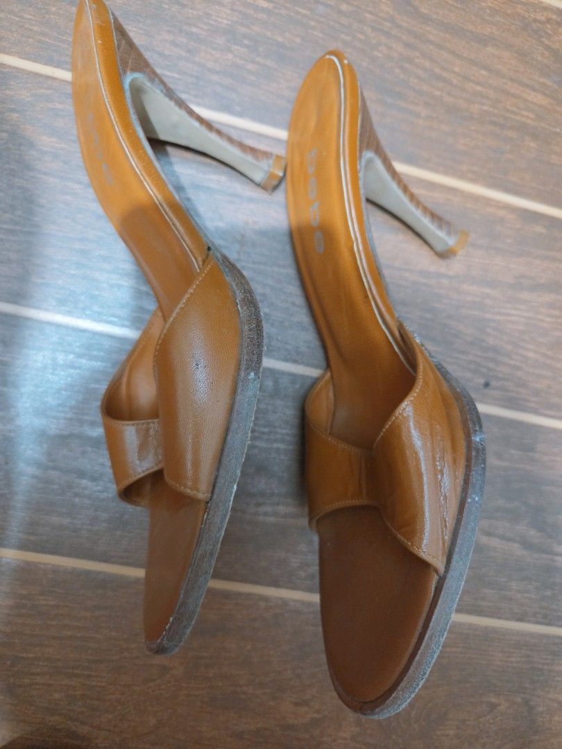 bebe brown leather slip-on high heel mules size 8 (Category: Heels) located in Manila. Submitted by titserghe07 (Listing ID 1470077672, Image 2). Description: - Brand: bebe - Color: Tan brown - Size: 8 (stamped on sole) - Style: Open toe, slide-on stiletto - Heel: Wooden finish with textured pattern - Material: Leather upper and sole (Made in Brazil) - Condition: Minor creasing on leather upper; heavy wear on bottom soles from outdoor walking.