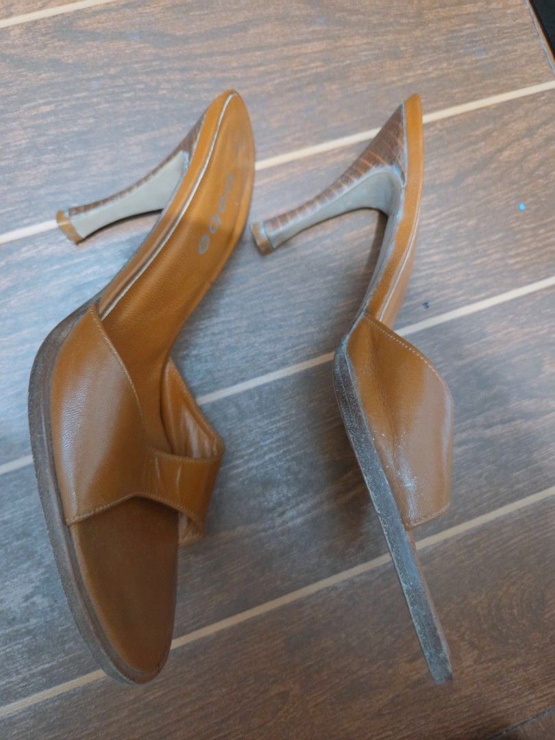 bebe brown leather slip-on high heel mules size 8 (Category: Heels) located in Manila. Submitted by titserghe07 (Listing ID 1470077672, Image 3). Description: - Brand: bebe - Color: Tan brown - Size: 8 (stamped on sole) - Style: Open toe, slide-on stiletto - Heel: Wooden finish with textured pattern - Material: Leather upper and sole (Made in Brazil) - Condition: Minor creasing on leather upper; heavy wear on bottom soles from outdoor walking.