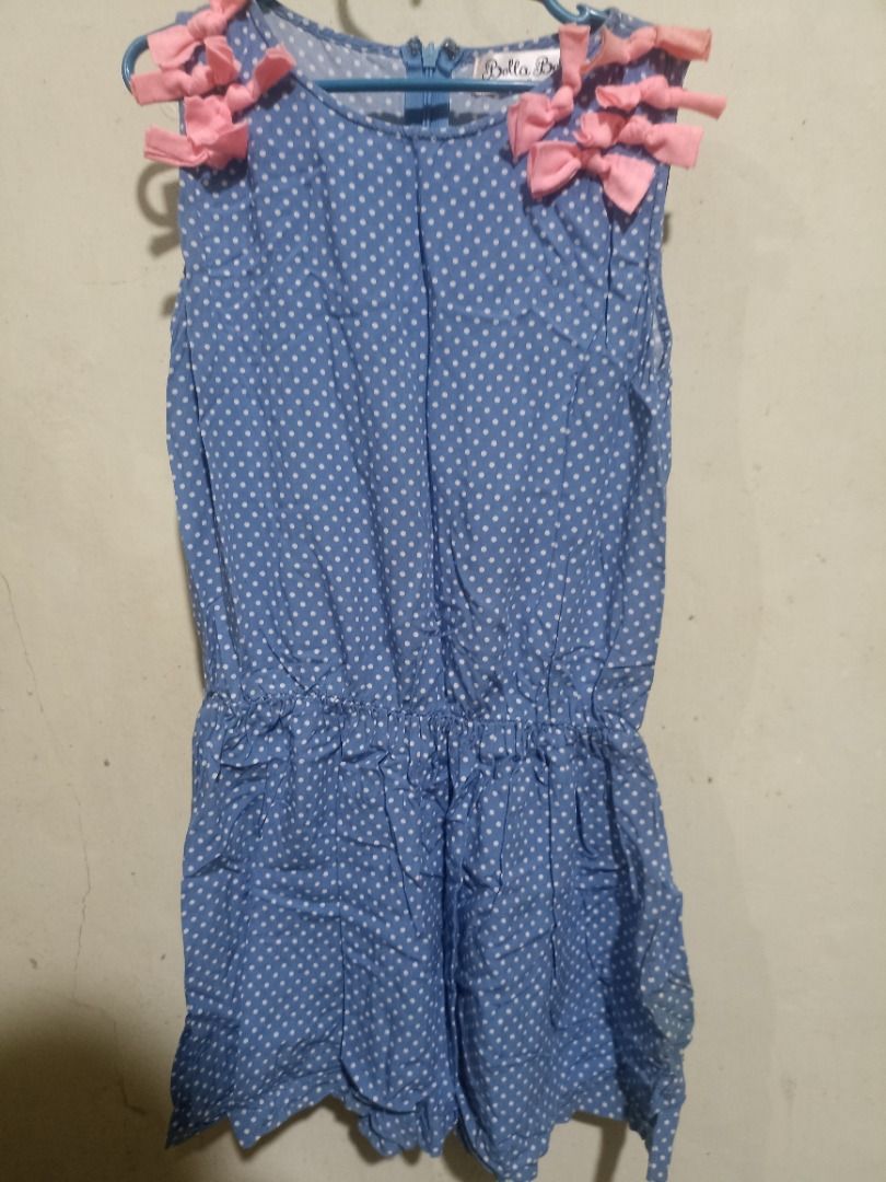 Bella Belle Blue Polka Dot Romper Size 8 (Category: Rompers) located in Binangonan. Submitted by livelion_f56acf (Listing ID 1470110451, Image 1). Description: - Color & Pattern: Blue with all-over white polka dots - Design: Sleeveless with a classic round neckline - Cute Detail: Adorable pink knotted ribbons on both shoulders - Closure: Convenient back zipper - Size: Tagged Size 8 - Condition: Excellent, well-loved - MOP: Gcash / Bank Transfer.