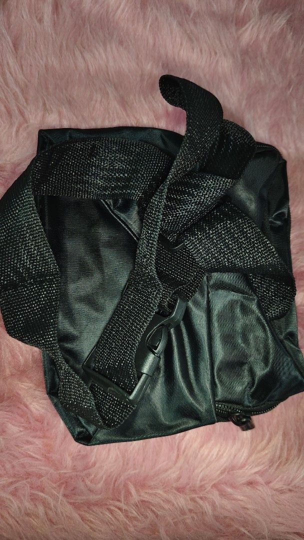 Belt bag black (Category: Belt bags, Clutches and Pouches) located in Pasay City. Submitted by taytayswifty (Listing ID 1469985926, Image 3). Description: - Color: Black - Material: Durable nylon - Compartments: Multiple zipped pockets for easy organization - Accent: Distinctive red Sport label on the front pocket - Strap: Adjustable with a secure plastic buckle closure - Best for: Running errands, working out, or casual daily use.