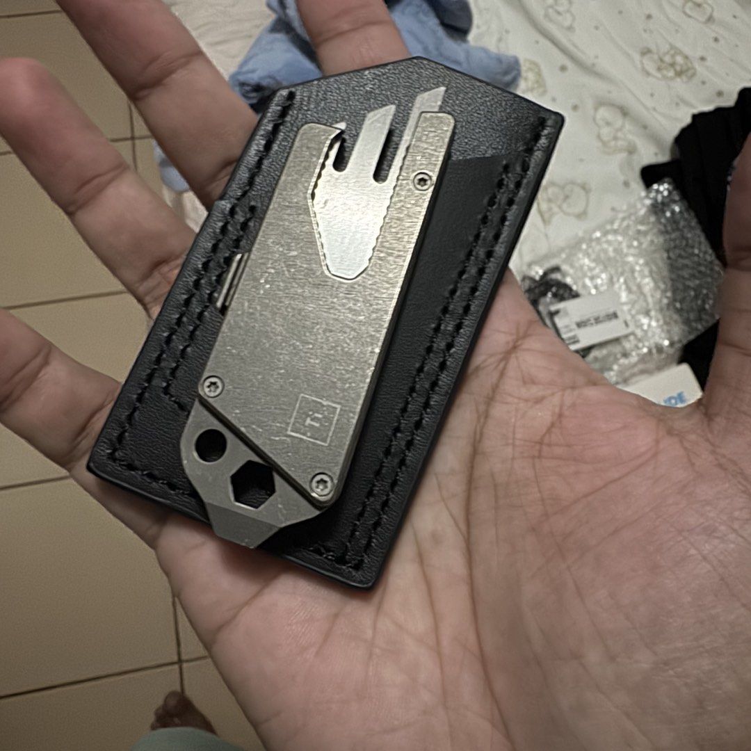 Big Idea design TPT slide titanium (Category: Hiking & Camping) located in Pasig City. Submitted by ampotampkin (Listing ID 1469991986, Image 1). Description: - Material: Premium titanium utility tool - Features: Integrated knife blade, bottle opener, and hex wrench cutouts - Storage: Includes a stylish black leather sleeve with black stitching - Condition: Minimal wear on the metal finish - Perfect for: Compact everyday carry (EDC) gear.