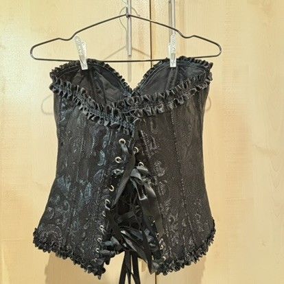 Black brocade corset top with lace up back (Category: Sleeveless) located in Quezon City. Submitted by slvrbullet (Listing ID 1470139965, Image 2). Description: - Color: Black with intricate floral brocade pattern - Details: Ruffled trim on top and bottom edges - Closure: Front hook-and-eye closures - Fit: Adjustable black ribbon lace-up back for custom sizing - Structure: Built-in boning for support with a clean interior lining.