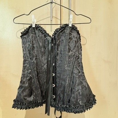 Black brocade corset top with lace up back (Category: Sleeveless) located in Quezon City. Submitted by slvrbullet (Listing ID 1470139965, Image 1). Description: - Color: Black with intricate floral brocade pattern - Details: Ruffled trim on top and bottom edges - Closure: Front hook-and-eye closures - Fit: Adjustable black ribbon lace-up back for custom sizing - Structure: Built-in boning for support with a clean interior lining.