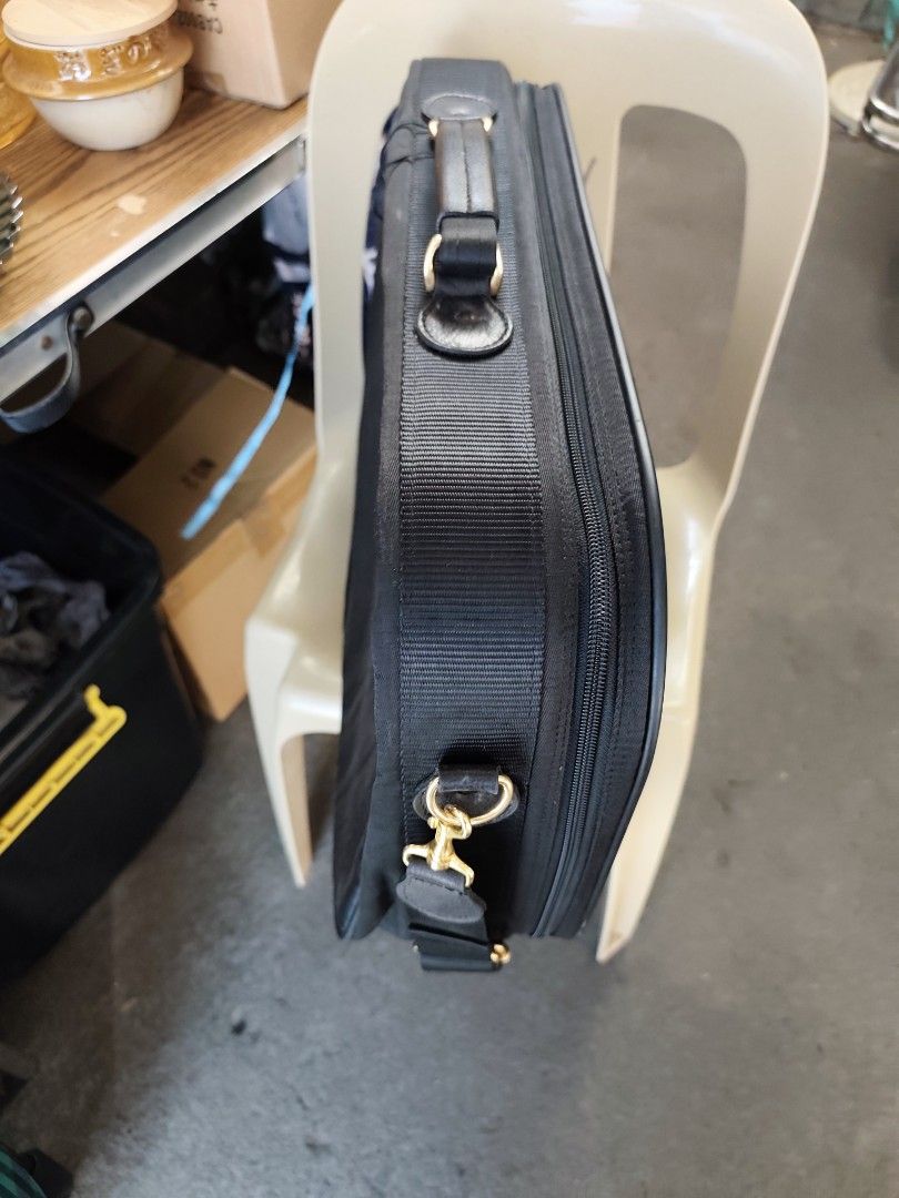 Black business travel briefcase with shoulder strap (Category: Briefcases) located in Bulacan. Submitted by gelvy1316 (Listing ID 1469951874, Image 2). Description: - Color: Professional black with chic gold-toned hardware - Carry Options: Sturdy top handle and a detachable shoulder strap with secure metal clasps - Exterior: Vertical zipper pocket on the front and a stylish logo patch - Interior: Wide-opening main compartment featuring packing st