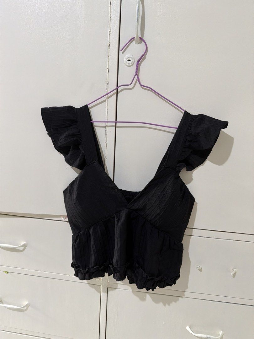 Black Cropped Ruffle Strap Top (Category: Sleeveless) located in Rizal. Submitted by kyliemaine (Listing ID 1470016738, Image 1). Description: - Color: Black - Design: Deep V-neckline with thick ruffled straps and ruffled hem - Texture: Textured fabric all over - Styling: Perfect to pair with high-waisted jeans or skirts.