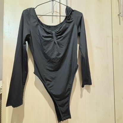 Black Long Sleeve Ruched Bodysuit (Category: Longsleeves) located in Quezon City. Submitted by slvrbullet (Listing ID 1470139961, Image 1). Description: - Color: Black - Style: Long sleeve bodysuit with fitted cut - Neckline & Back: Scoop neck and scoop back - Details: Trendy ruched front and high-cut leg opening - Fabric: Smooth and stretchy for a comfortable fit - Versatility: Great for layering or wearing on its own.