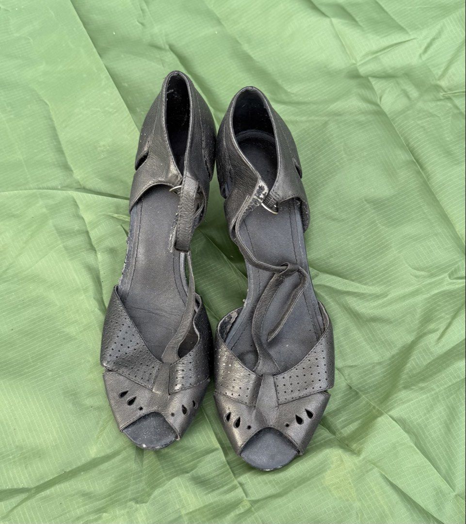 Black metallic peep-toe wedge sandals with T-strap design (Category: Wedges) located in Cavite. Submitted by maxs.bl (Listing ID 1469956484, Image 1). Description: - Color/Finish: Metallic black - Style: Peep-toe wedge sandals with T-strap and ankle buckle closure - Details: Perforated cut-outs and teardrop accents on upper straps - Heel: Substantial wedge for added height and stability - Condition: Pre-owned with light scuffing and wear on the i