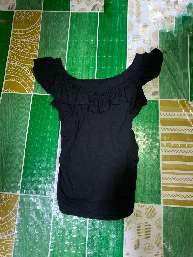 Black Ruffle Off-Shoulder Top (Category: Blouses) located in Cebu City. Submitted by selamethrift (Listing ID 1470062547, Image 1). Description: - Color: Black - Style: Short-sleeve slim fit with ruffled neckline - Fabric: Stretchy and comfortable - Condition: Worn a few times, no stains or holes - Versatile basic piece, easy to match with jeans or skirts.