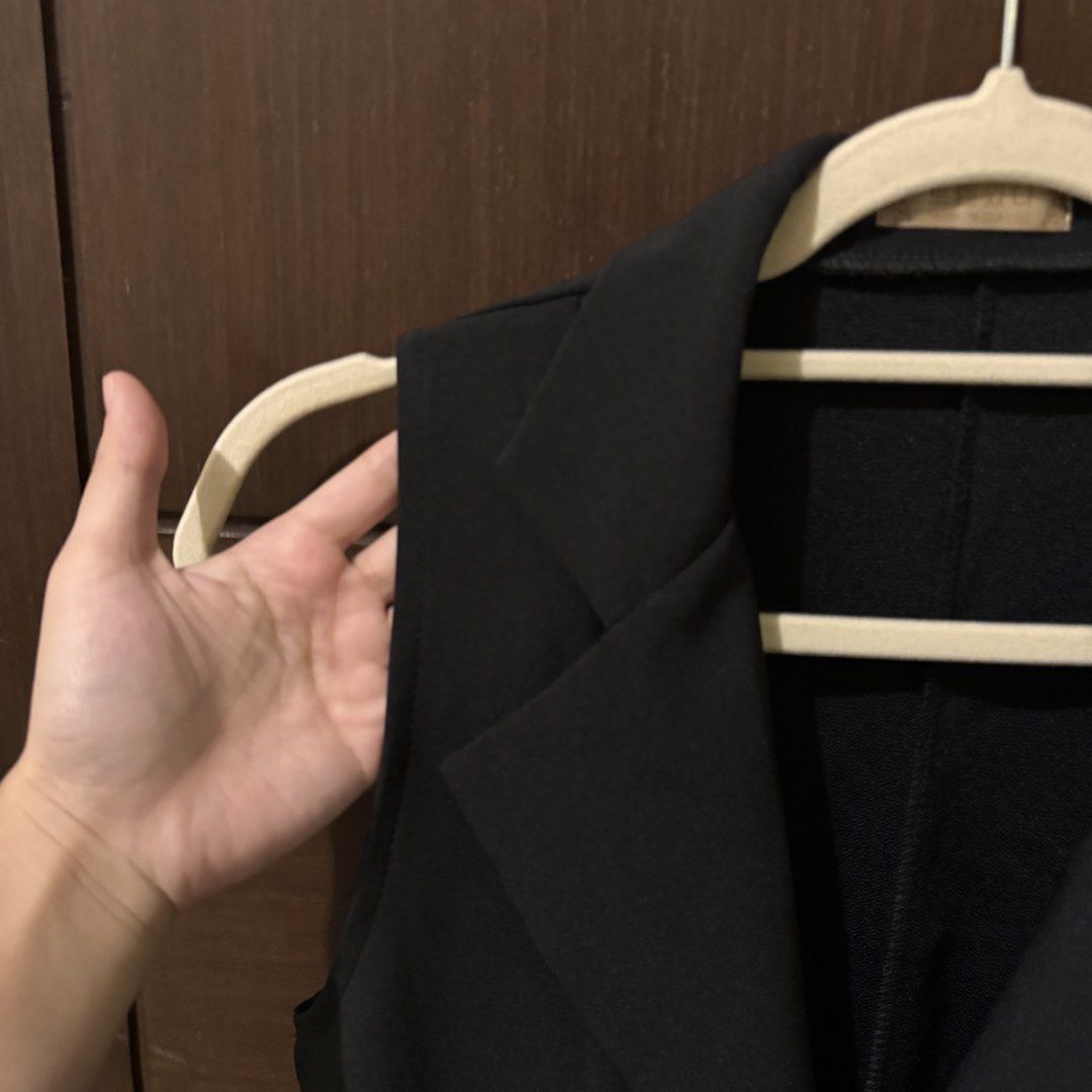 Black Sleeveless Long Vest Coat Blazer (Category: Sleeveless) located in Quezon City. Submitted by ianne.declutter (Listing ID 1470049951, Image 3). Description: - Style: Black sleeveless long vest with lapel collar - Closure: Single front button - Pockets: Two deep side pockets - Fit: Mid-thigh length, lightweight structured fabric - Origin: Korean brand - Condition: Clean, no tears or loose threads - Versatility: Great layering piece over shirt